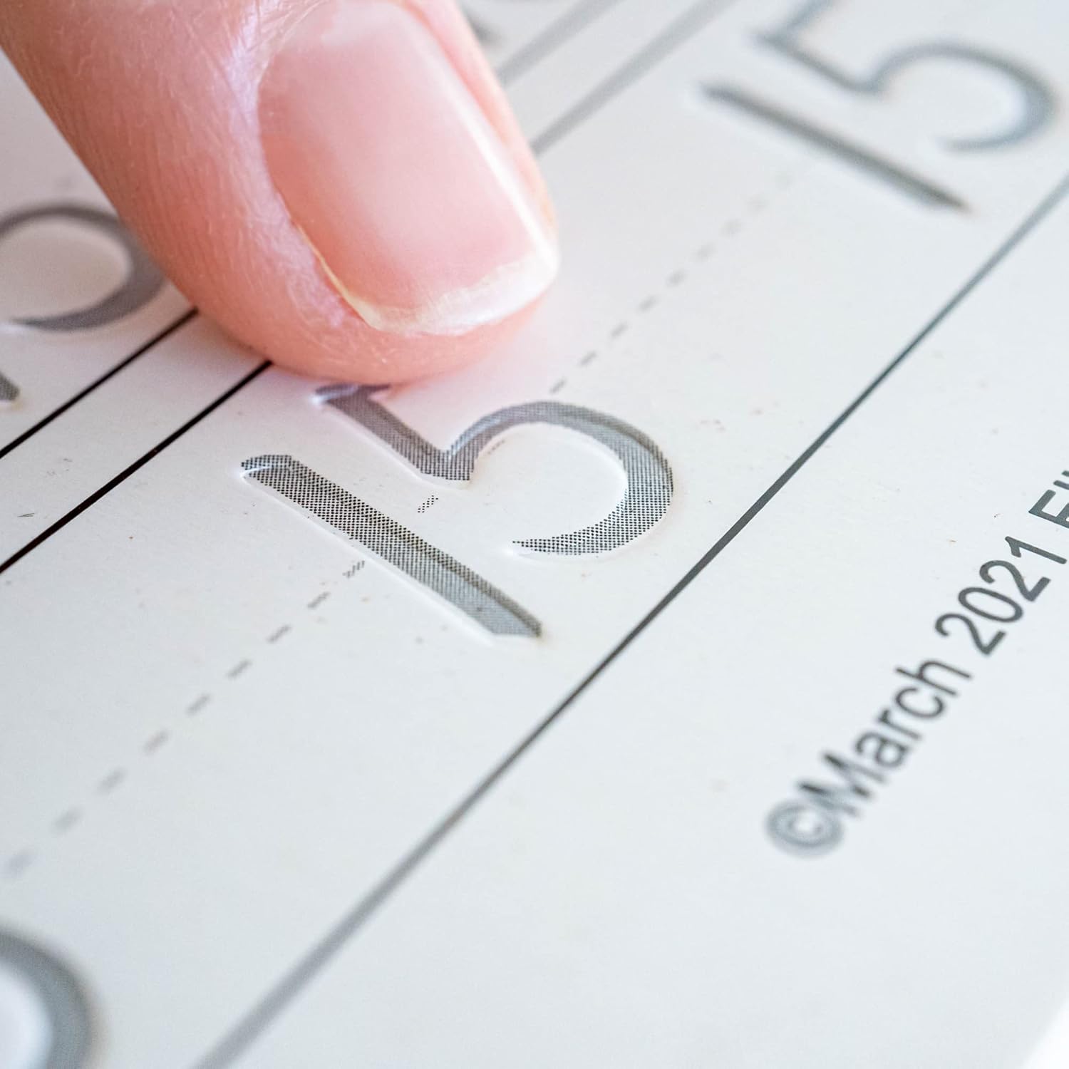 Close-up of finger highlighting grooved indentation on Magic Copybook page for guided letter tracing.